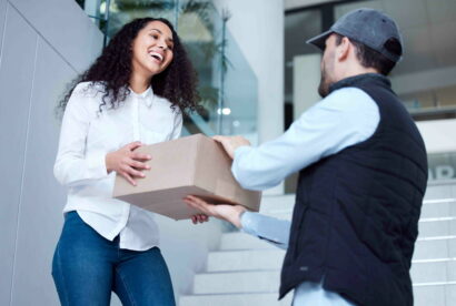 Shot of a young woman receiving her delivery from the courier.