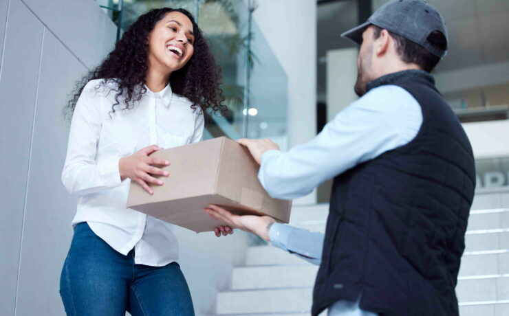 Shot of a young woman receiving her delivery from the courier.